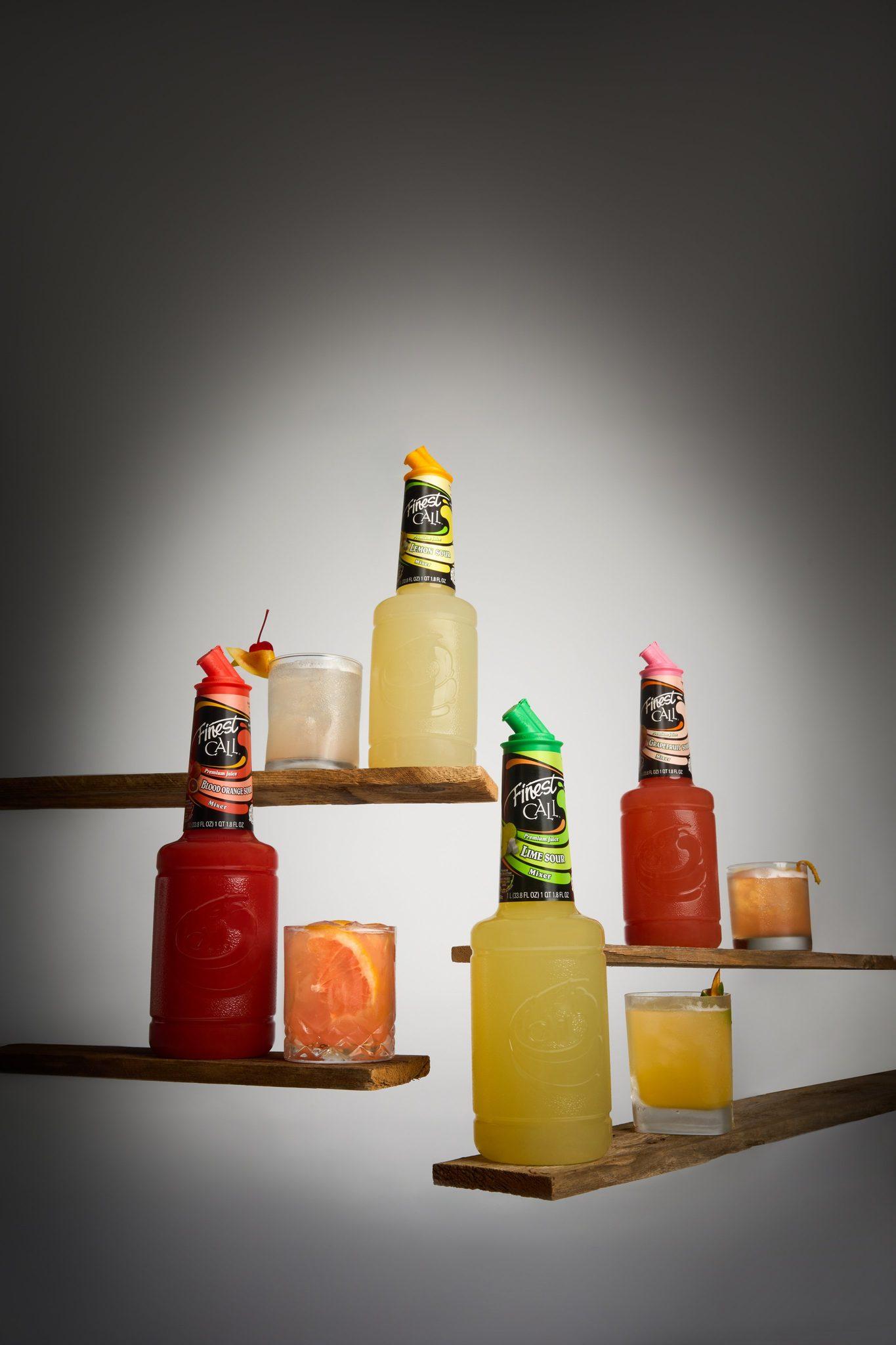 Finest Call bottles arranged on wooden bar shelves with accompanying cocktails